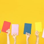 Many books in hands on a yellow background