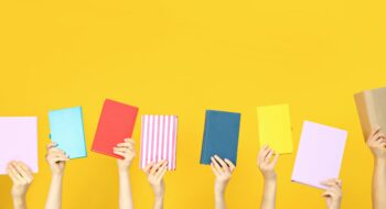 Many books in hands on a yellow background