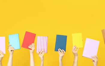 Many books in hands on a yellow background